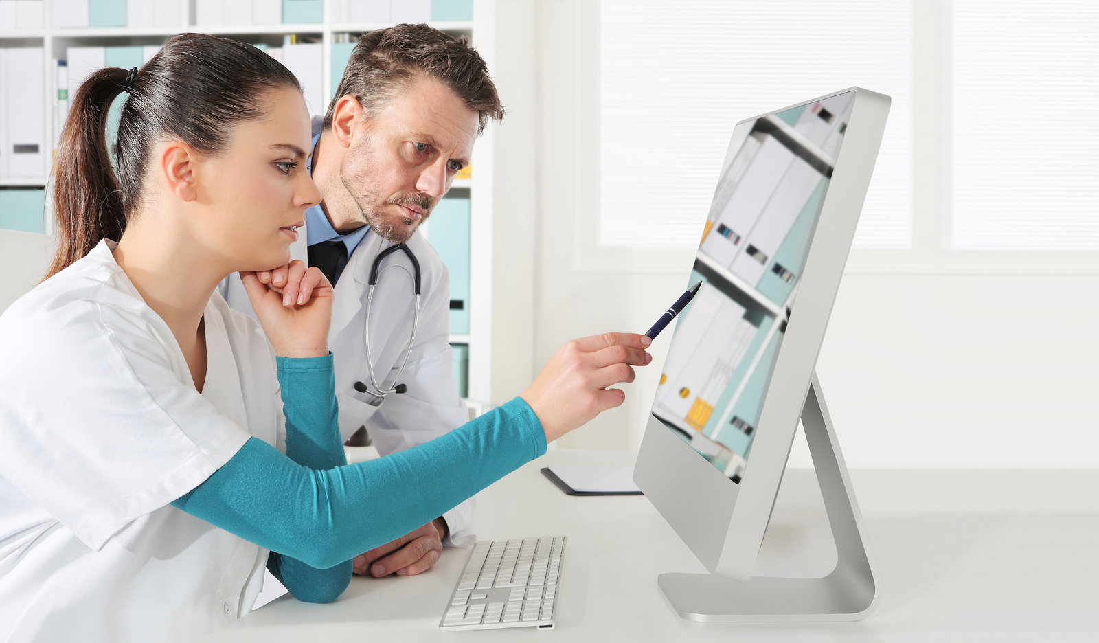 Doctor and nurse review patient information on remote population management technology platform