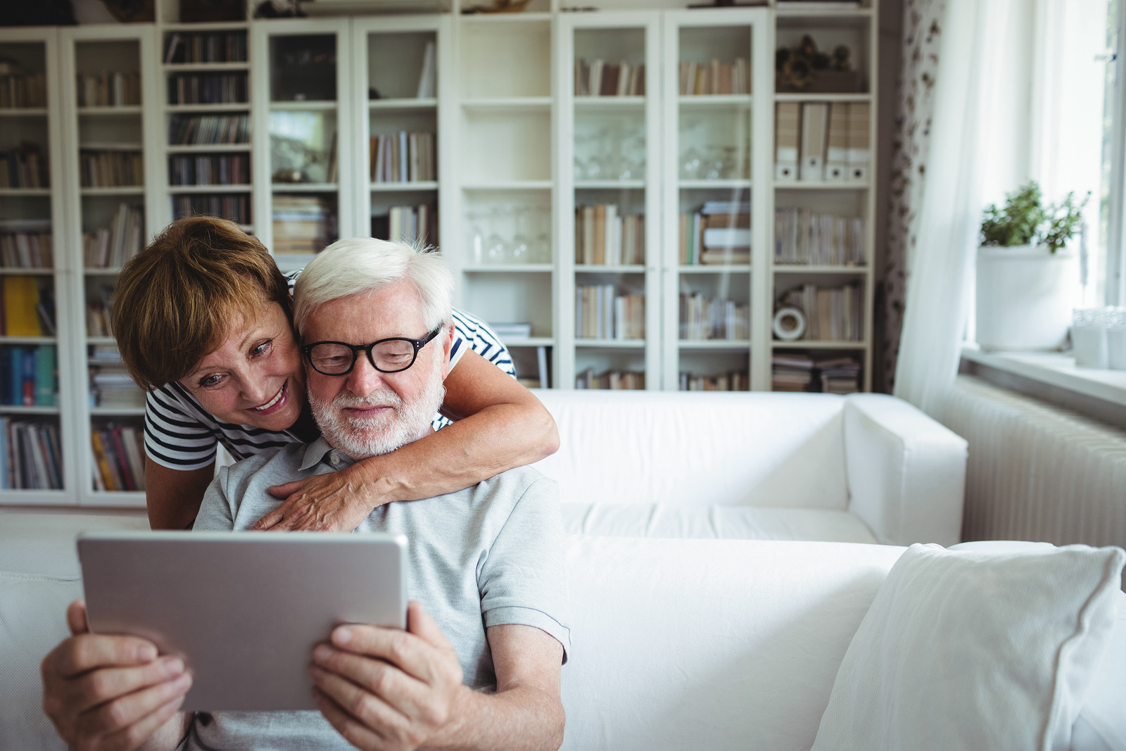 Senior couple using digital tablet in living room