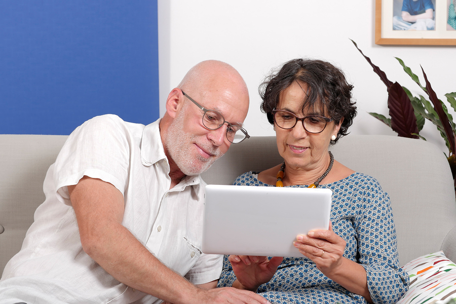 A senior couple using a tablet and smiling