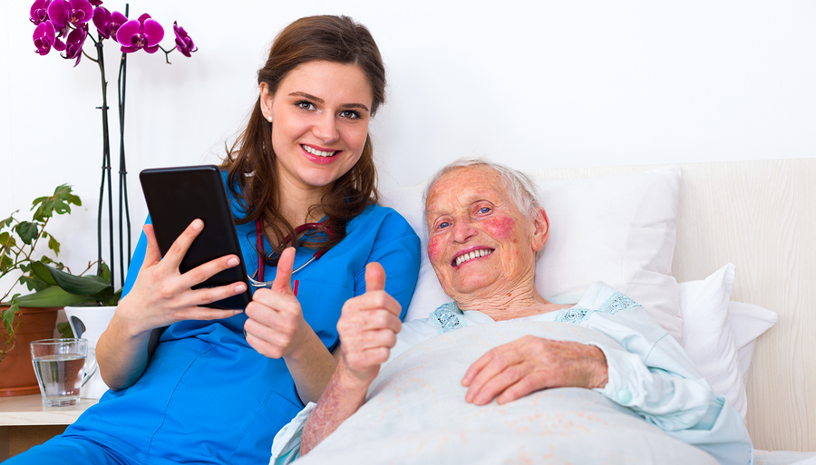 Doctor and senior patient showing thumbs-up at the nursing home using digital tablet.